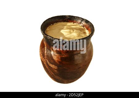 Clay pot with baked milk, isolated on white background. Stock Photo