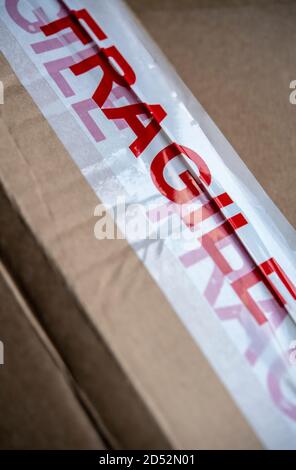 Packaging tape marked fragile on a cardboard box Stock Photo