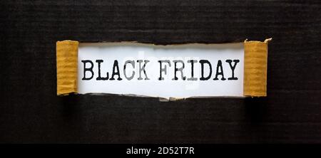 The words 'black friday' appearing behind torn black paper. Beautiful background. Business concept. Stock Photo