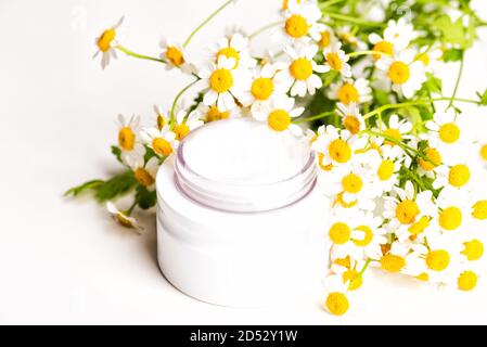 Plastic bottle of essence or serum and with chamomile flowers Stock Photo