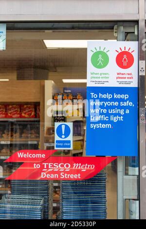 Signage seen at the Tesco metro supermarket in Dean Street, which has a traffic light system to let shoppers know when it is safe to enter the store so it can adhere to social distancing restrictions. Stock Photo