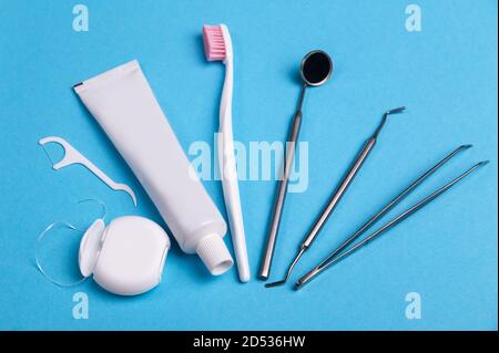 Dentist tools and dental hygiene products on a blue background. Floss, brush and mouthwash. From the top view, flat lay. Stock Photo