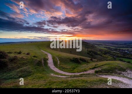 Sunset over Fulking village and views towards truleigh hiill and the sea on the South Downs National Park from Devil's Dyke, Sussex, England Stock Photo