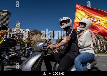 Protesters are seen mounted on a motorcycle carrying a Spanish flag during the celebration of the march of vehicles to commemorate Hispanic Day at the Columbus monument.Social entities of the Spanish political right, summoned by Somatemps and Vox have paid tribute to Hispanidad at the monument to Columbus to honour Hispanidad Day. Stock Photo