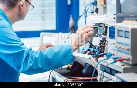 Electronics engineer troubleshooting defects in a hardware product Stock Photo