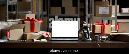 Table with boxes and mockup laptop screen. Online ecommerce sale, banner Stock Photo