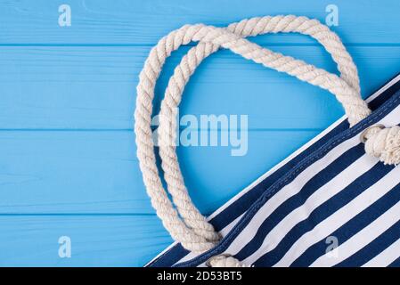 Summer vacation concept. Top above overhead view photo of blue striped bag isolated on blue wooden background Stock Photo