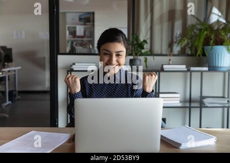 Excited indian woman read good news on laptop Stock Photo