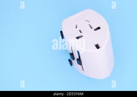 adapter electric adapter multifunctional white on a blue background. Stock Photo