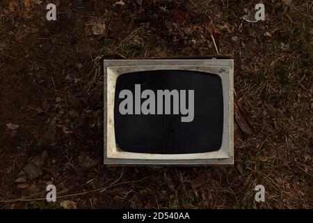 old broken TV on the ground with a black screen. Stock Photo