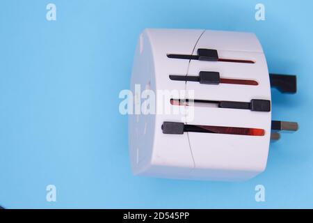 adapter electric adapter multifunctional white on a blue background. Stock Photo