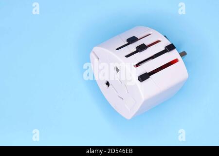 adapter electric adapter multifunctional white on a blue background. Stock Photo