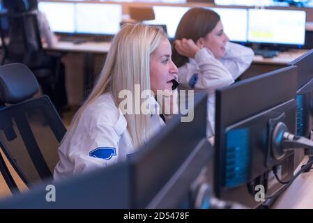 Female security guards working in surveillance room, monitoring cctv and discussing. Stock Photo