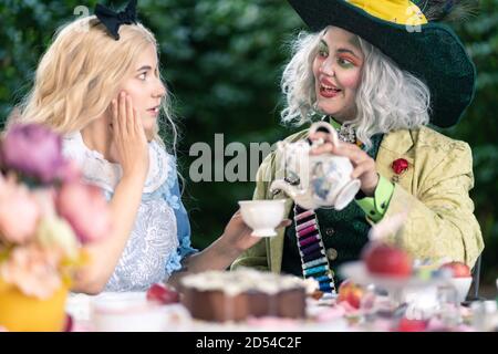 MUNICH, GERMANY - Sep 12, 2020: Cosplayer as characters from Alice in Wonderland. Tea party with Alice, the crazy hatter and the white queen Stock Photo