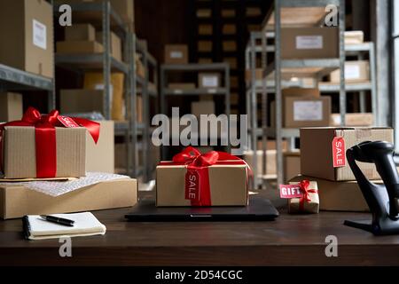 Table with gift parcel boxes on table in warehouse. Online ecommerce sale. Stock Photo