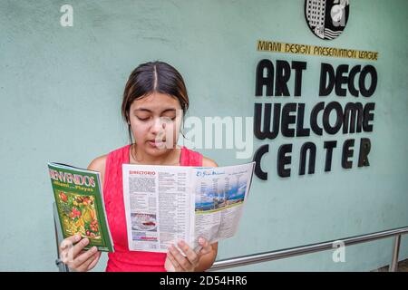 Miami Beach Florida,South Beach,Ocean Drive,Welcome Center centre,Hispanic woman female tourist reads reading Spanish language,information brochure le Stock Photo