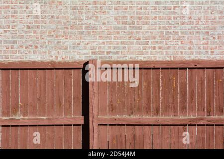 Textured background of brown weathered wooden fence and brick wall Stock Photo