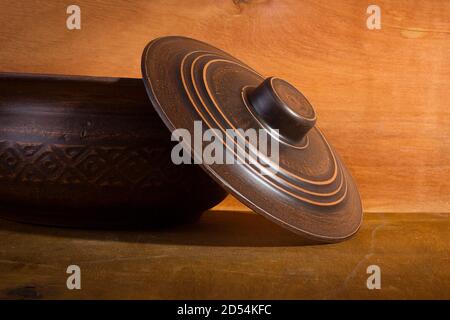 Earthenware with lid on wooden table close up Stock Photo