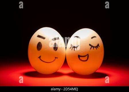 egg faces of lovely couple highlighted in dark Stock Photo