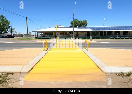 Bright yellow pedestrian crossing leading to the Post Office Hotel, a typical old Outback pub at Camooweal, Barkly Highway, Queensland, QLD, Australia Stock Photo