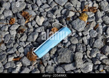 A discarded face mask used to protect one from the Covid 19 virus then thrown away Stock Photo