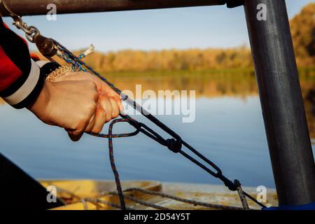 A mans hands tie a sea knot on a light yacht. Stock Photo