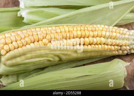 One ear of corn, slightly peeled. Rustic style. Close up. Stock Photo