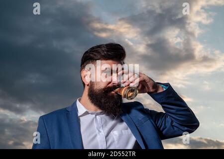 Man with beard holds glass brandy. Bearded guy drink cognac. Man holding a glass of whisky. Sipping whiskey. Portrait of man with thick beard Stock Photo