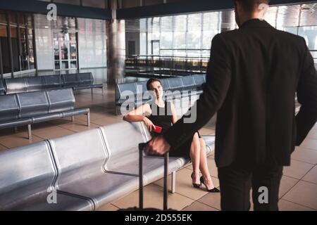 Cheerful woman waiting for her partner at the airport Stock Photo