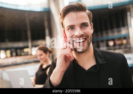 Joyful handsome man making a business phone call Stock Photo