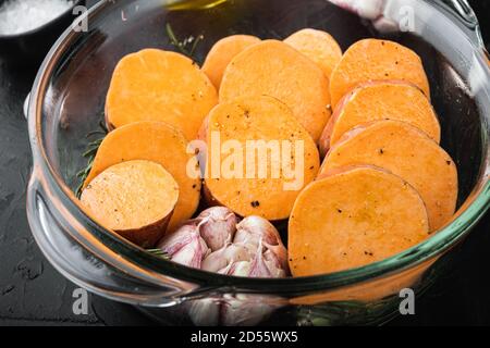 Cajun sweet potatoes for baking with herbs and spices on black background Stock Photo