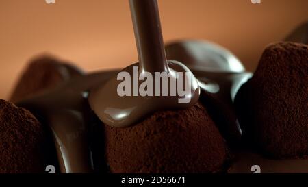 Detail of pralines with pouring melted chcocolate on top. Studio macro shot. Stock Photo