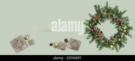 Christmas, border with realistic shiny pink gift boxes, floral Xmas wreath with fir branches on green pastel horizontal background. Gold text Merry Christmas, Copy space, mock. 3D Illustration. Stock Photo