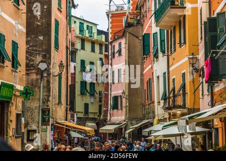 Gorgeous street view of Via Roma, the main street in Vernazza, in the Cinque Terre region. The busy street with typical colourful medieval tower... Stock Photo