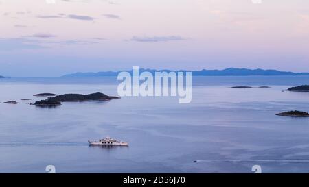 Looking down on a car ferry and a small speed boat on the Peljesac Channel in Croatia in October 2017 from a high vantage point. Stock Photo