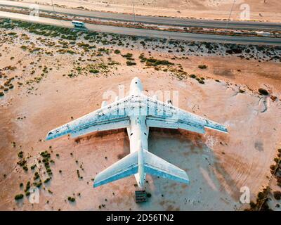 Abandoned airplane in the in the Umm Al Quwain desert in the emirate of the United Arab Emirates aerial view at sunrise Stock Photo