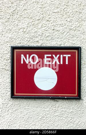 White words No Exit sign on red background on wall Stock Photo