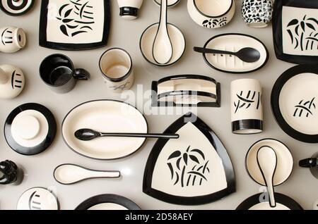 Creative composition made with Square, Circular, Oval and Triangle Shaped Crockery. Design made with Plates, Bowls and spoons. Grey Background. Indoor Stock Photo