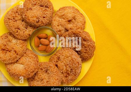 Anarasa a typical Maharashtrian delicacy arranged in a yellow colored plate. Indian pastry-like snack commonly associated with Diwali festival Stock Photo