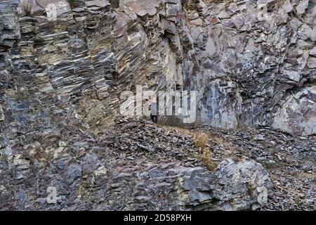 Professional photographer documenting various rock types in an abandoned ancient quarry Stock Photo