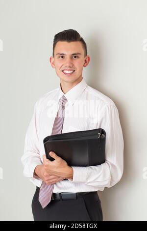 Portrait of a smiling businessman holding a leather folder Stock Photo