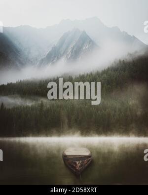 Rowing boat on a lake in front of a pine forest and mountains in the fog, Lemolo Lake, Oregon, USA Stock Photo