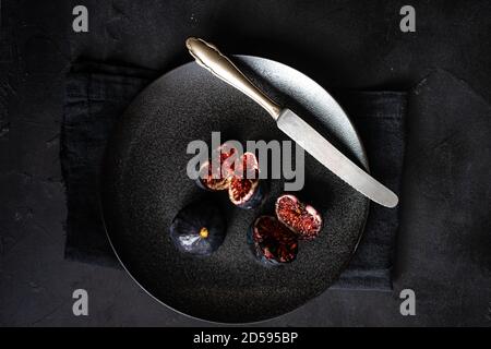 Overhead view of purple figs on a plate Stock Photo