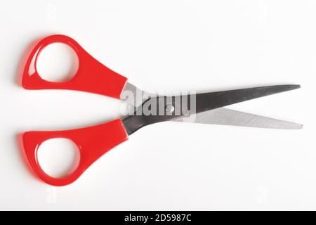 A pair of scissors with bright red handles, open as if about to cut. Stock Photo