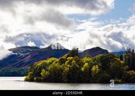 View across Derwentwater to Cat Bells beyond autumn trees on Derwent Isle in Lake District National Park. Keswick, Cumbria, England, UK, Britain Stock Photo
