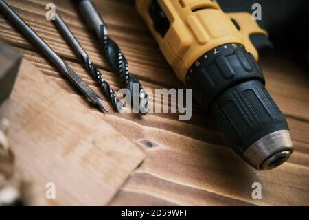 Close up of screwdriver with different drills on the wooden table . Stock Photo