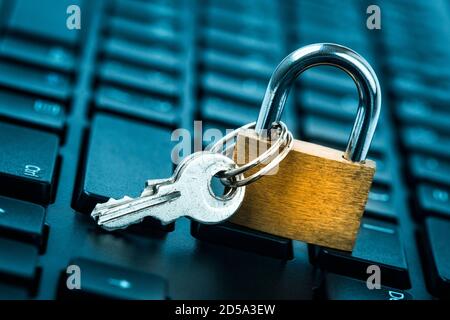 Computer security concept. Locked padlock on laptop keyboard. Security lock on computer keyboard - computer protection concept. Selective focus on key Stock Photo