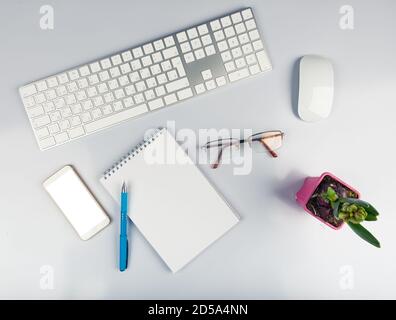 Office desk table with computer keyboard, supplies, flower. Top view with copy space Stock Photo