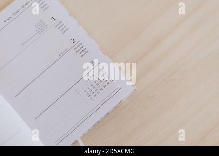 an open planner in the 2021 calendar, is on top of a wooden desk Stock Photo