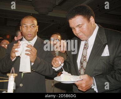 Boxing Great Muhammad Ali R Eats A Piece Of His Birthday Cake As Boxer Mike Tyson Looks On At The Mgm Grand Hotel In Las Vegas Nevada In This January 17 1999